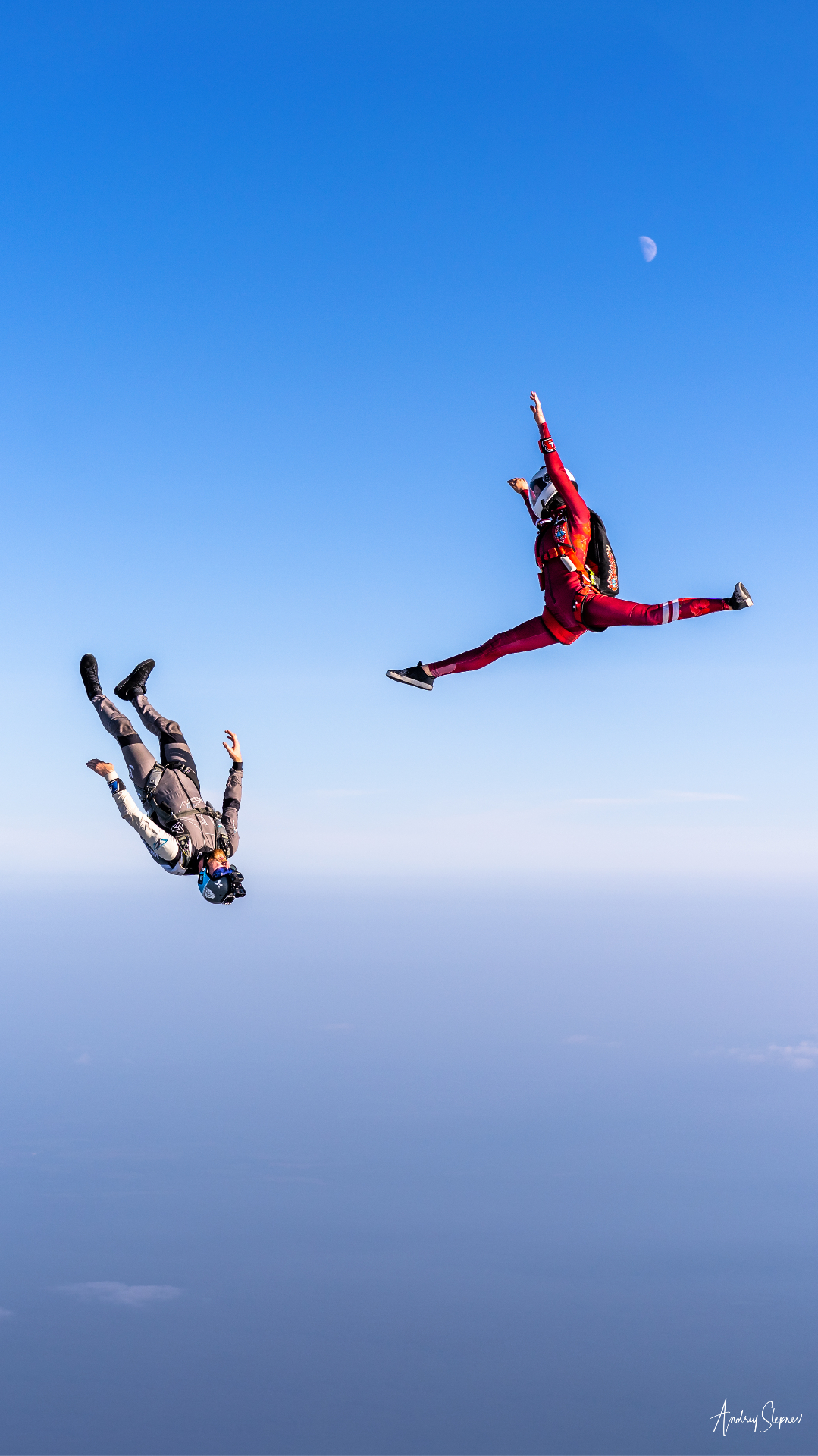 Two skydivers in freefall against a blue sky